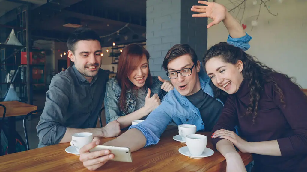 young adults taking a selfie in a café